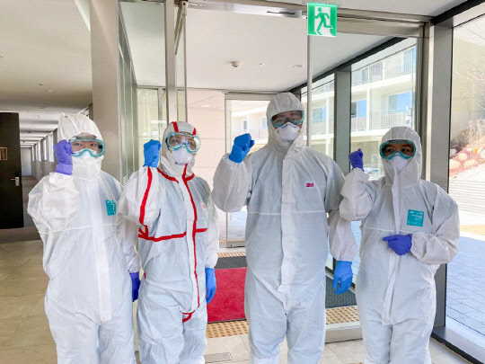 지난 4월 삼성이 제공한 영덕 생활치료센터에서 입소 환자의 검체 채취를 준비하는 의료진들이 화이팅 포즈를 취하고 있다.   <삼성전자 제공>